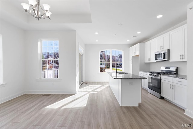 kitchen with white cabinets, light wood-type flooring, stainless steel appliances, and plenty of natural light