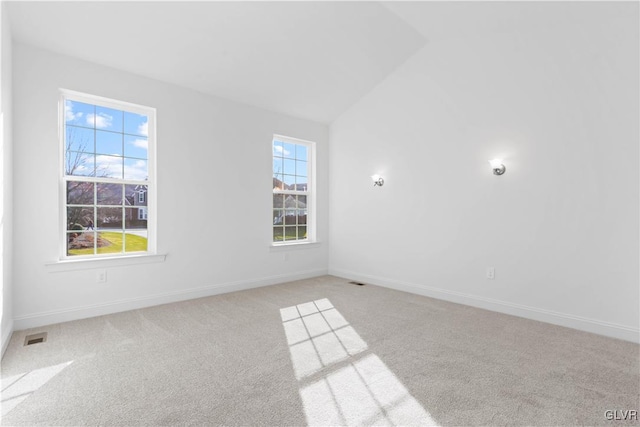 carpeted empty room featuring lofted ceiling