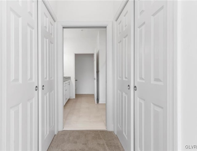 hallway featuring light colored carpet