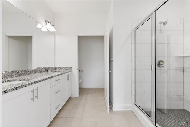 bathroom with vanity, toilet, and a shower with door