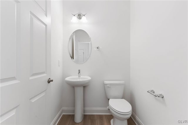 bathroom featuring sink, wood-type flooring, and toilet