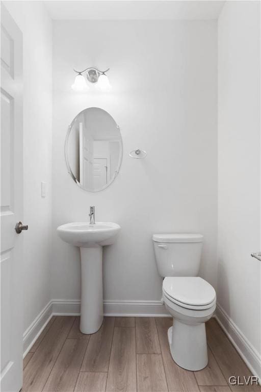 bathroom with hardwood / wood-style floors and toilet