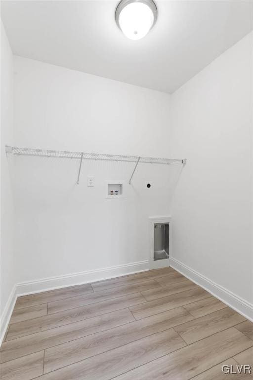 clothes washing area with electric dryer hookup, light hardwood / wood-style floors, and washer hookup