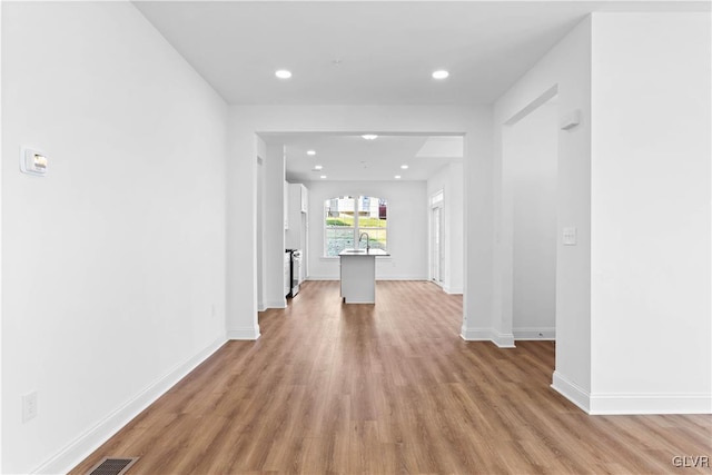 hallway featuring light wood-type flooring and sink