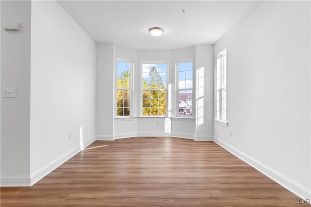 unfurnished room with hardwood / wood-style flooring