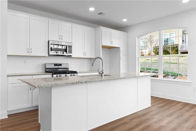 kitchen featuring white cabinetry, an island with sink, and stainless steel appliances