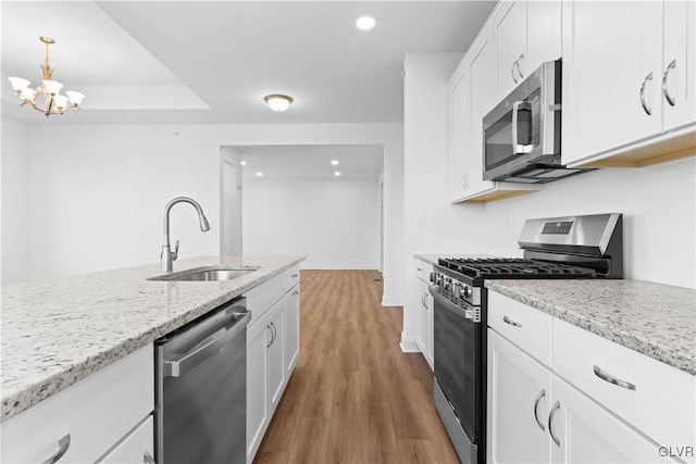 kitchen featuring dark wood-type flooring, white cabinets, sink, light stone countertops, and stainless steel appliances