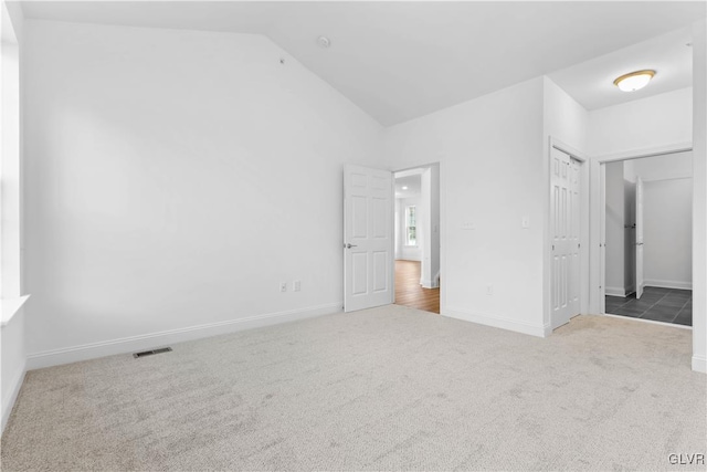 unfurnished bedroom with carpet floors, vaulted ceiling, and a closet