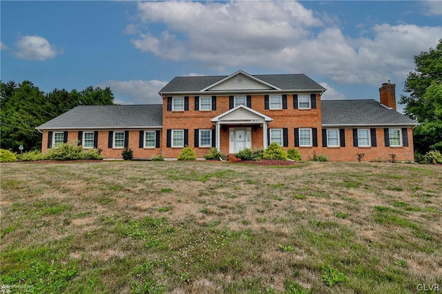 colonial-style house with a front lawn