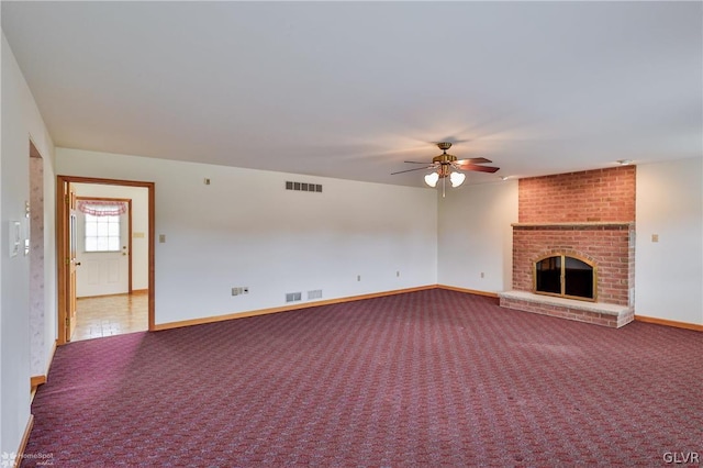 unfurnished living room with brick wall, carpet, a fireplace, and ceiling fan