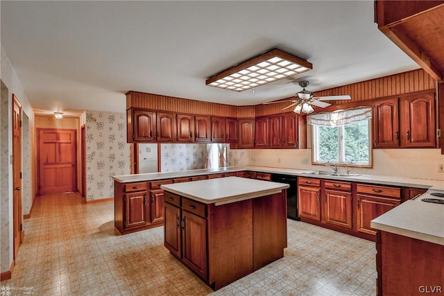 kitchen featuring black dishwasher, sink, light tile patterned floors, a center island, and ceiling fan