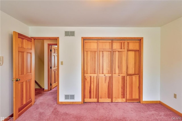 unfurnished bedroom with a closet and light colored carpet