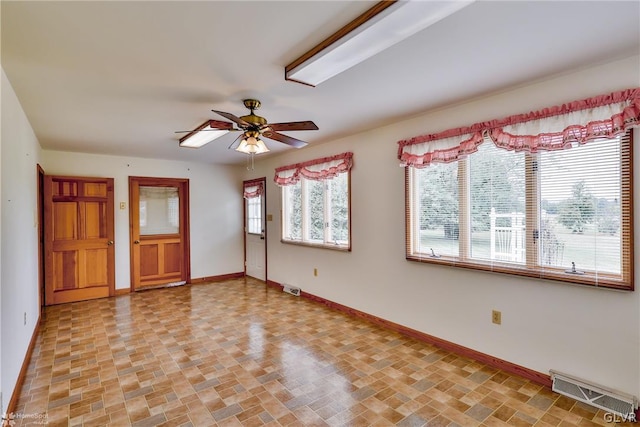 tiled spare room featuring a wealth of natural light and ceiling fan