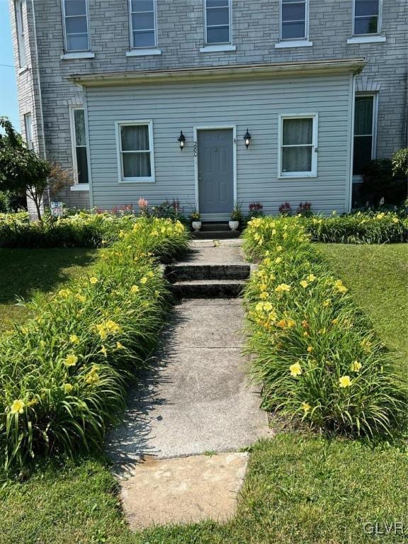 entrance to property featuring a lawn