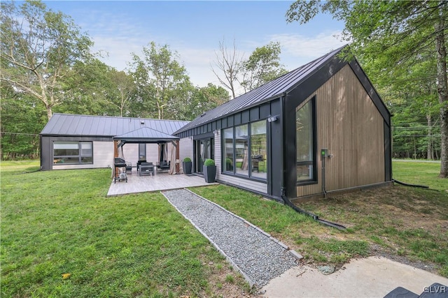 rear view of property featuring a patio area, a gazebo, and a yard