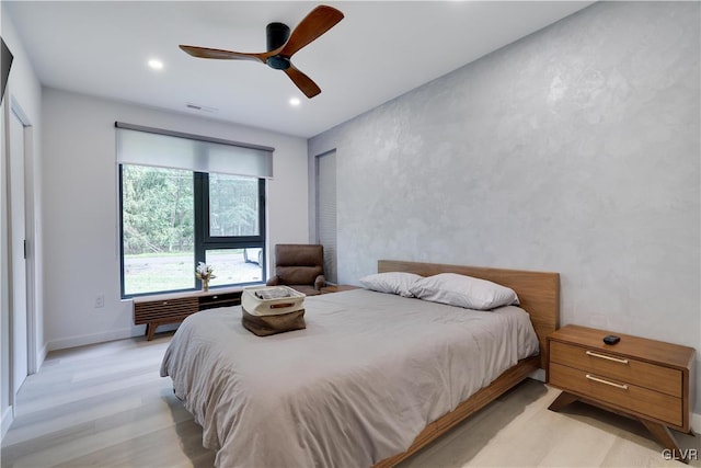 bedroom with ceiling fan, light hardwood / wood-style flooring, and a closet