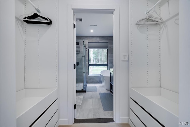 spacious closet with light tile patterned floors