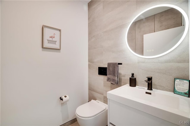 bathroom with decorative backsplash, tile walls, vanity, and toilet