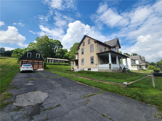 view of front of house with a porch, a garage, and a front lawn