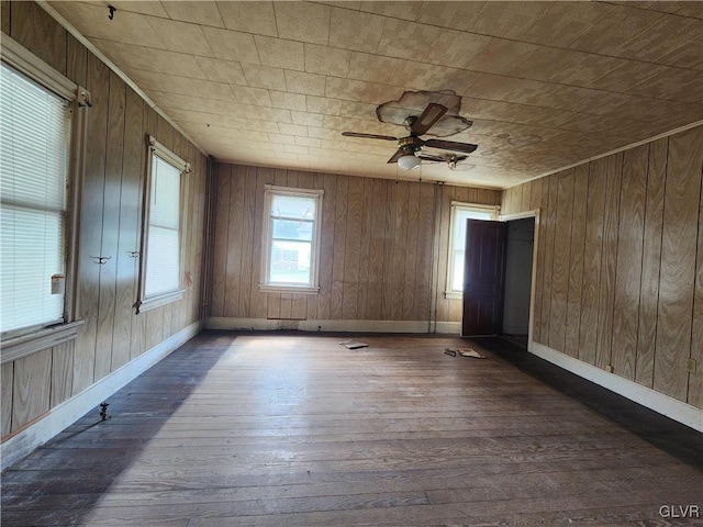 unfurnished room featuring wood walls, ceiling fan, and dark hardwood / wood-style floors