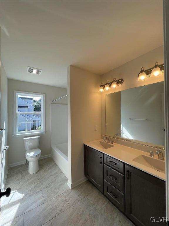 full bathroom featuring washtub / shower combination, toilet, tile patterned floors, and vanity