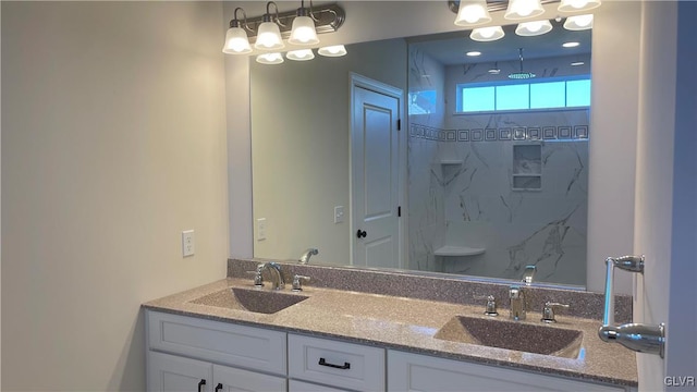 bathroom with a tile shower and vanity