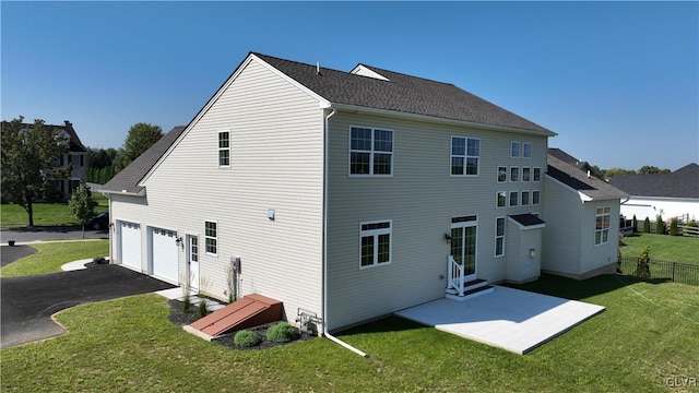 rear view of house with a garage and a yard