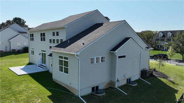 rear view of property featuring central air condition unit and a lawn