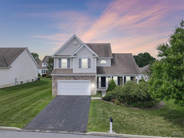 view of front of property featuring a garage and a lawn