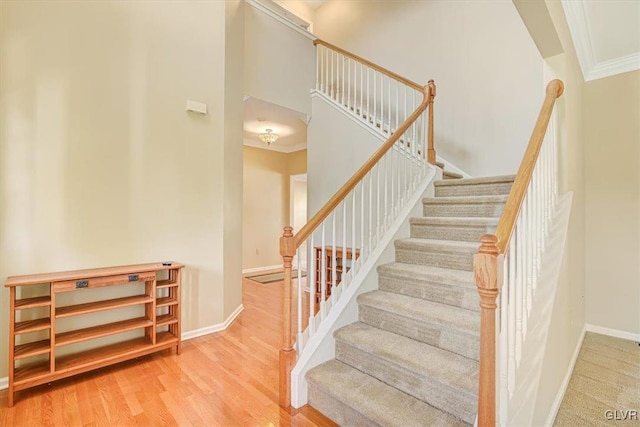 stairs with crown molding and hardwood / wood-style floors