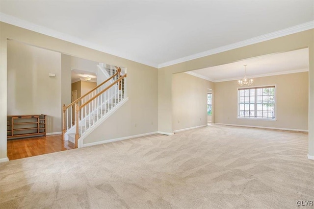 carpeted spare room with a chandelier and ornamental molding