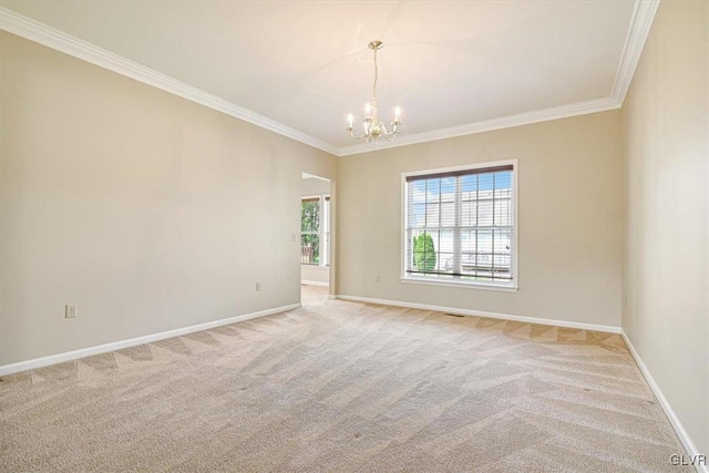 carpeted spare room featuring ornamental molding and a chandelier