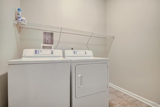 laundry room featuring washing machine and dryer and light tile patterned floors