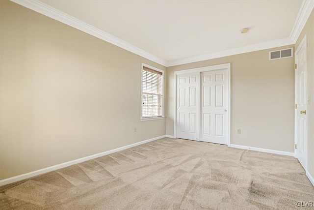 unfurnished bedroom with a closet, carpet floors, and ornamental molding