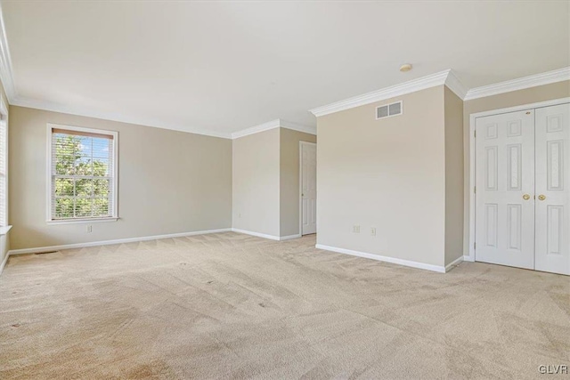 carpeted spare room featuring crown molding