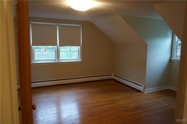 additional living space with lofted ceiling, a baseboard radiator, baseboards, and wood finished floors