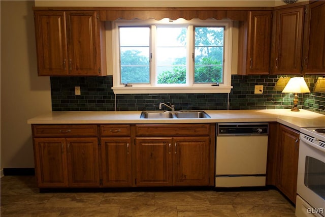 kitchen featuring light countertops, white appliances, a sink, and decorative backsplash