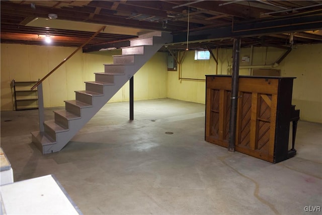 basement with electric panel and stairway