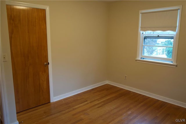 unfurnished room featuring wood finished floors and baseboards