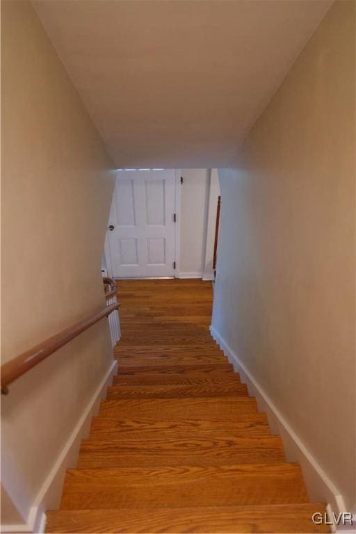 stairway with baseboards and wood finished floors