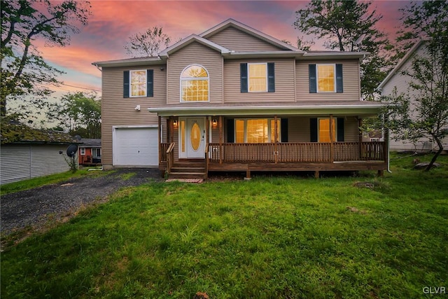 view of front of property with a porch, a garage, and a lawn