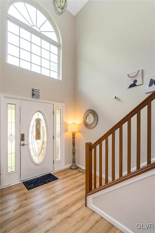 foyer featuring light hardwood / wood-style floors and a towering ceiling