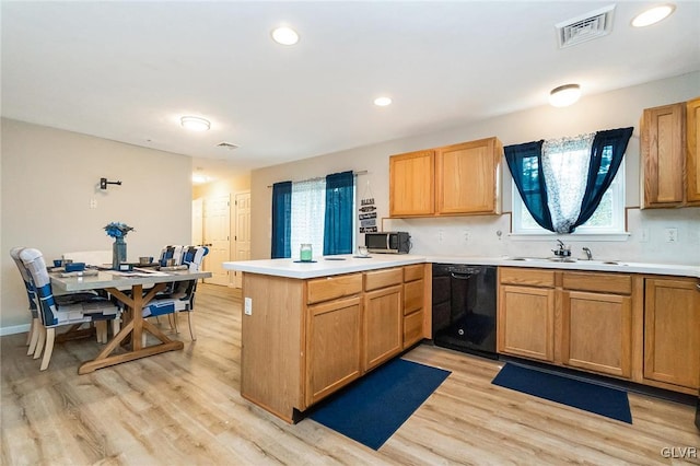 kitchen featuring sink, dishwasher, kitchen peninsula, and light hardwood / wood-style flooring