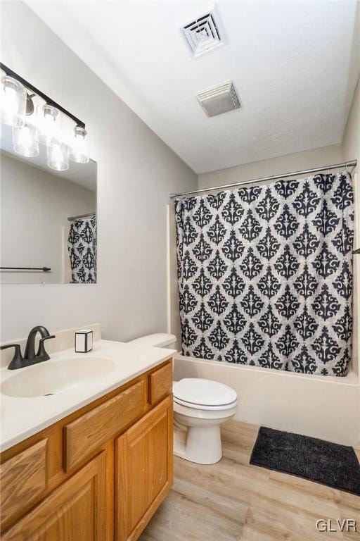 full bathroom featuring vanity, toilet, wood-type flooring, and shower / bath combo