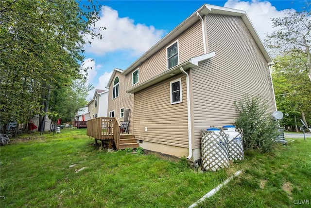 back of property featuring a deck and a lawn