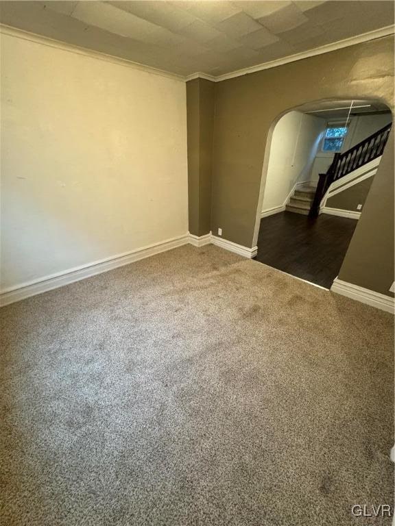 unfurnished room featuring dark carpet and crown molding