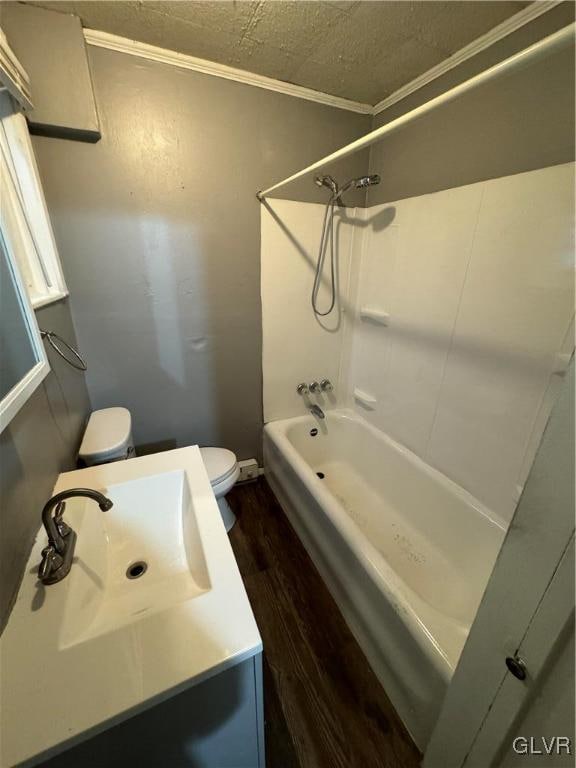 full bathroom with shower / washtub combination, toilet, hardwood / wood-style floors, ornamental molding, and vanity