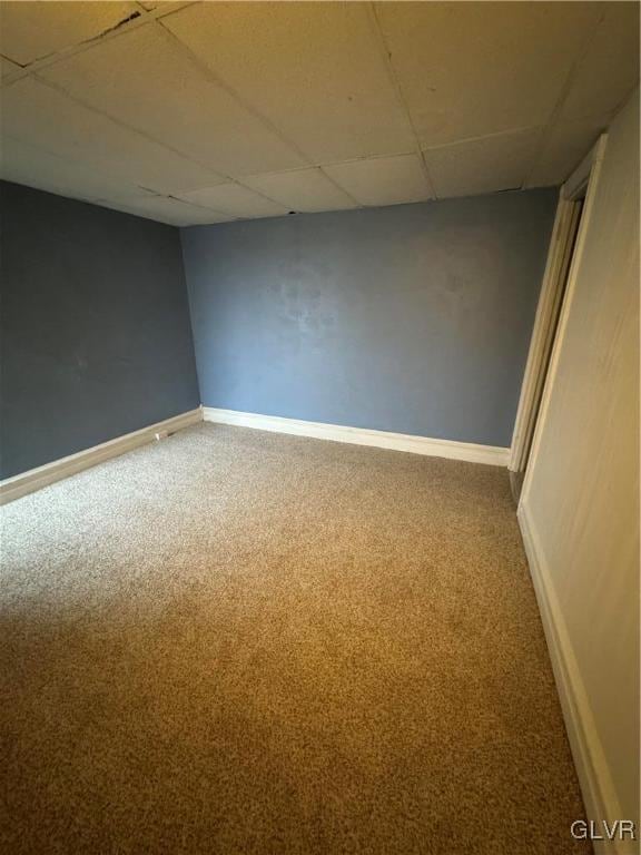 carpeted spare room featuring a drop ceiling