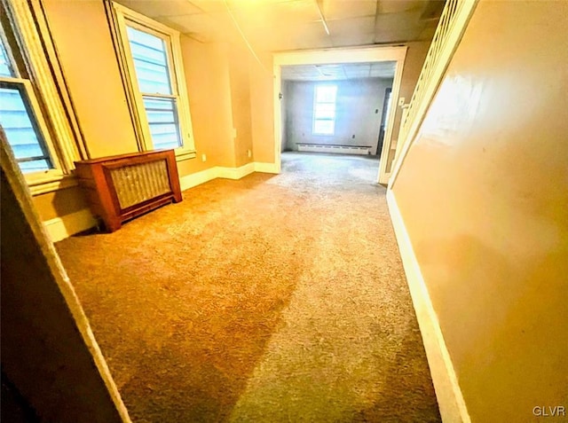 hall with baseboard heating and carpet