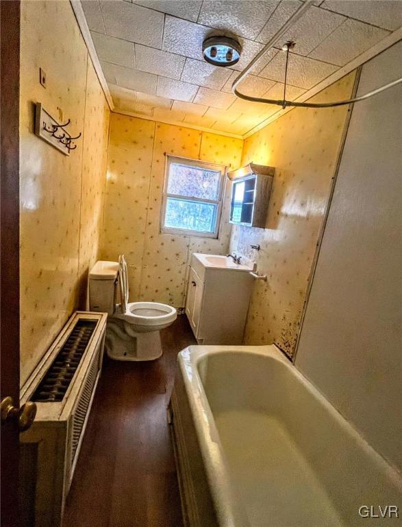 bathroom featuring a tub, toilet, vanity, and hardwood / wood-style flooring